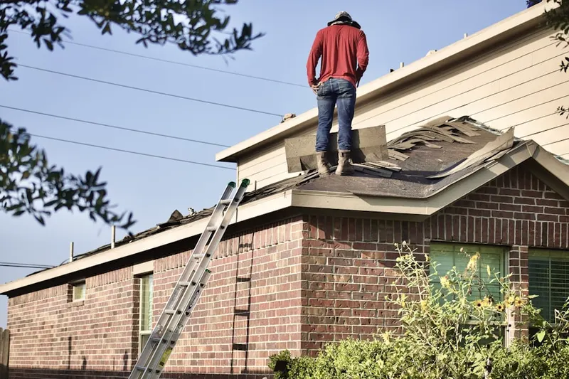 Professional roofer working on a residential roof in Ranch at Highland Meadows